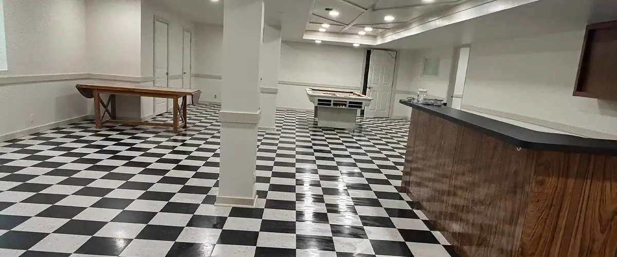 Basement remodel with black and white checkered flooring and bar area