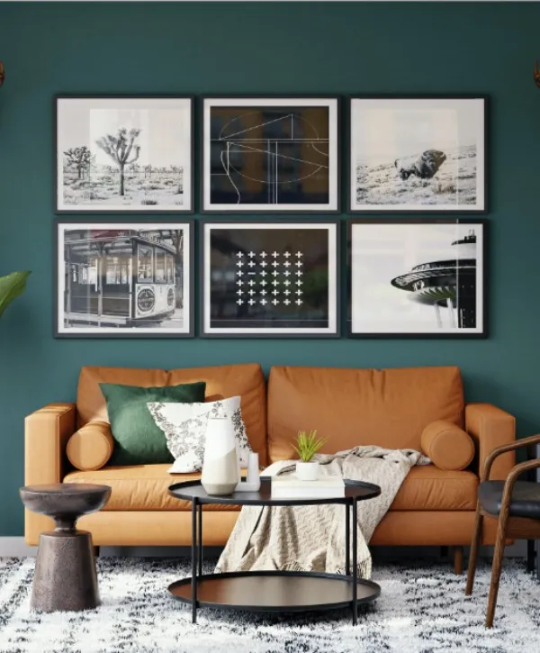A cozy living room featuring a couch, coffee table, and framed pictures on the wall.