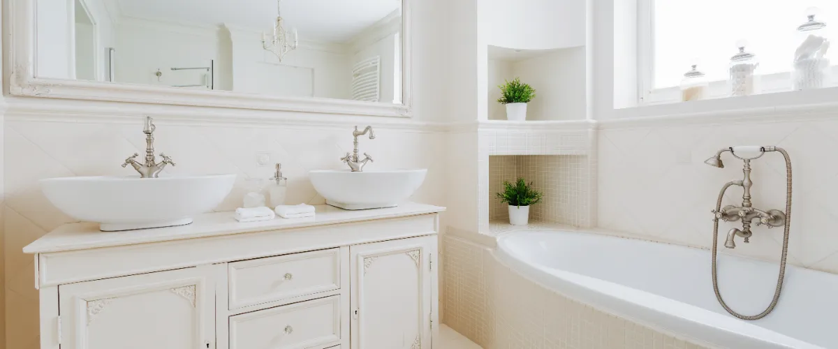 a bright, traditional-style bathroom featuring white fixtures and cabinets