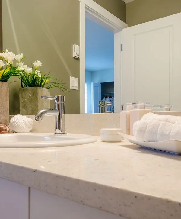 Close-up of a bright white quartz countertop and chrome faucet from a bathroom remodeling in Papillion, NE.