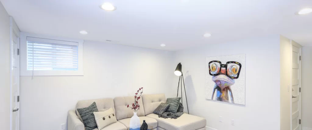 A spacious kitchen flooded with natural lighting from floor-to-ceiling windows during a sunny day.