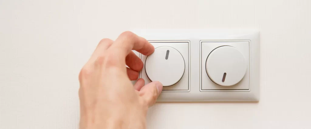 Close-up of sleek dimmer controls installed on a neutral wall for precise room atmosphere adjustment.