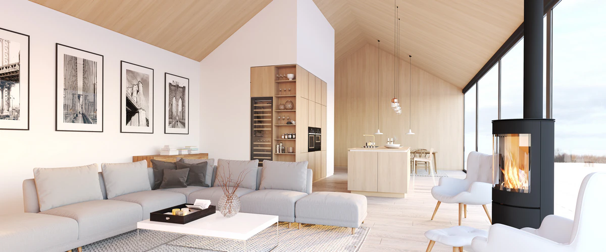 A minimalist home design featuring high vaulted wood ceilings, a sleek black cylindrical fireplace, and large floor-to-ceiling windows overlooking a snowy winter landscape.