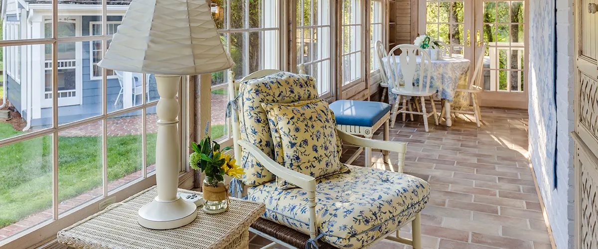 Bright sunroom with large windows, wicker furniture, and cozy indoor-outdoor home design