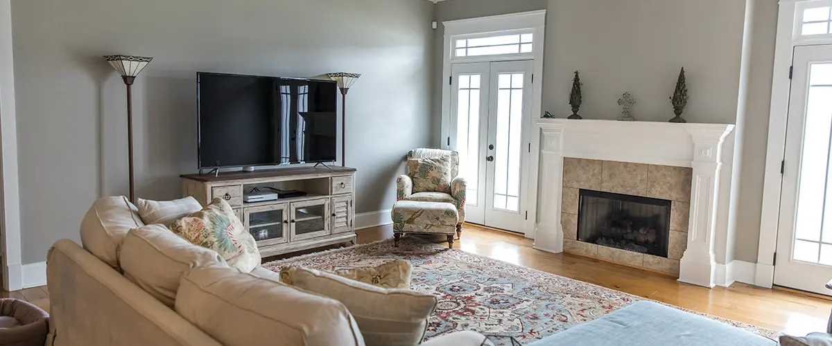 Spacious living room with fireplace, ceiling fan, and modern home staging decor